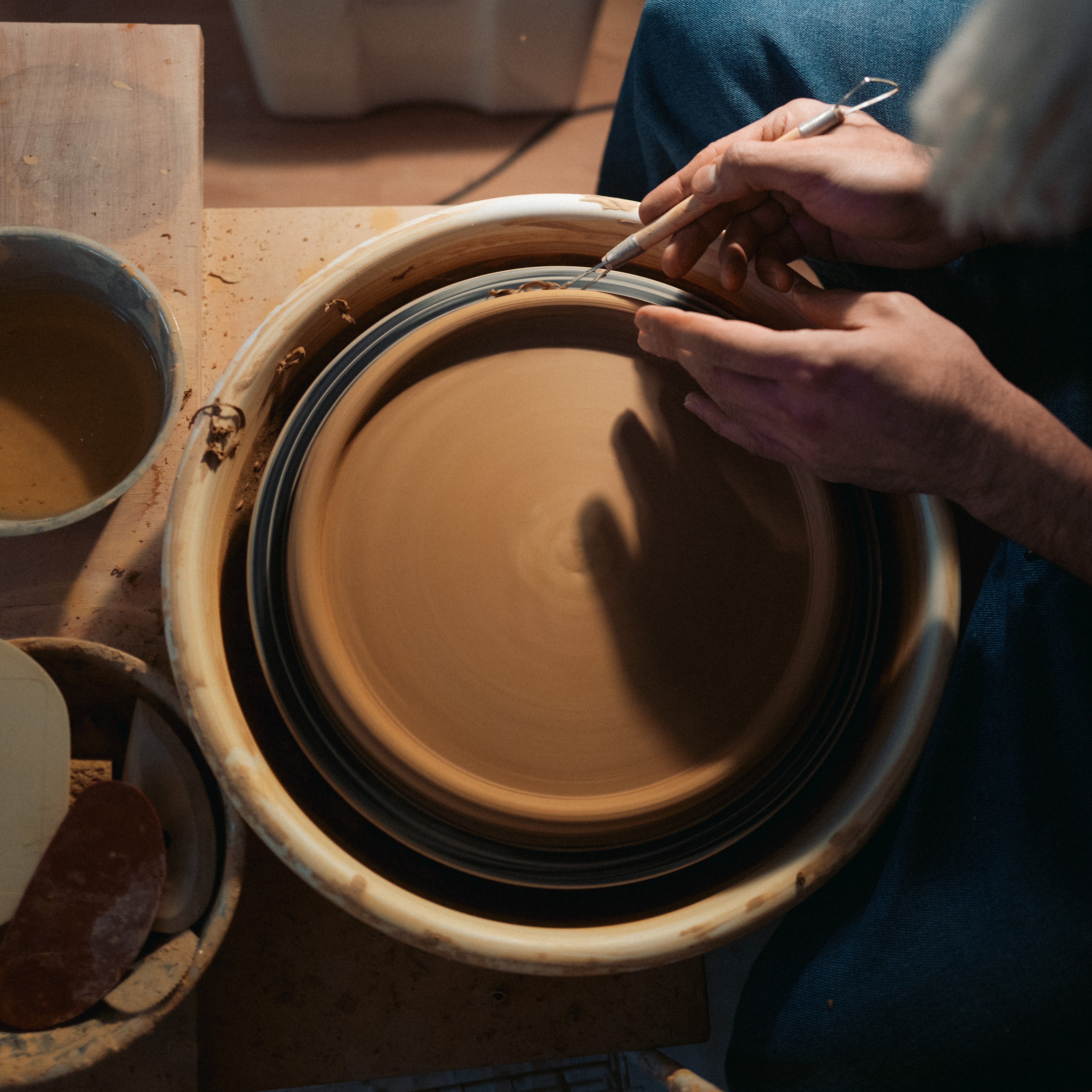 Töpferkurs an der Scheibe — Hände an der drehenden Töpferscheibe im Atelier Zamini Osnabrück